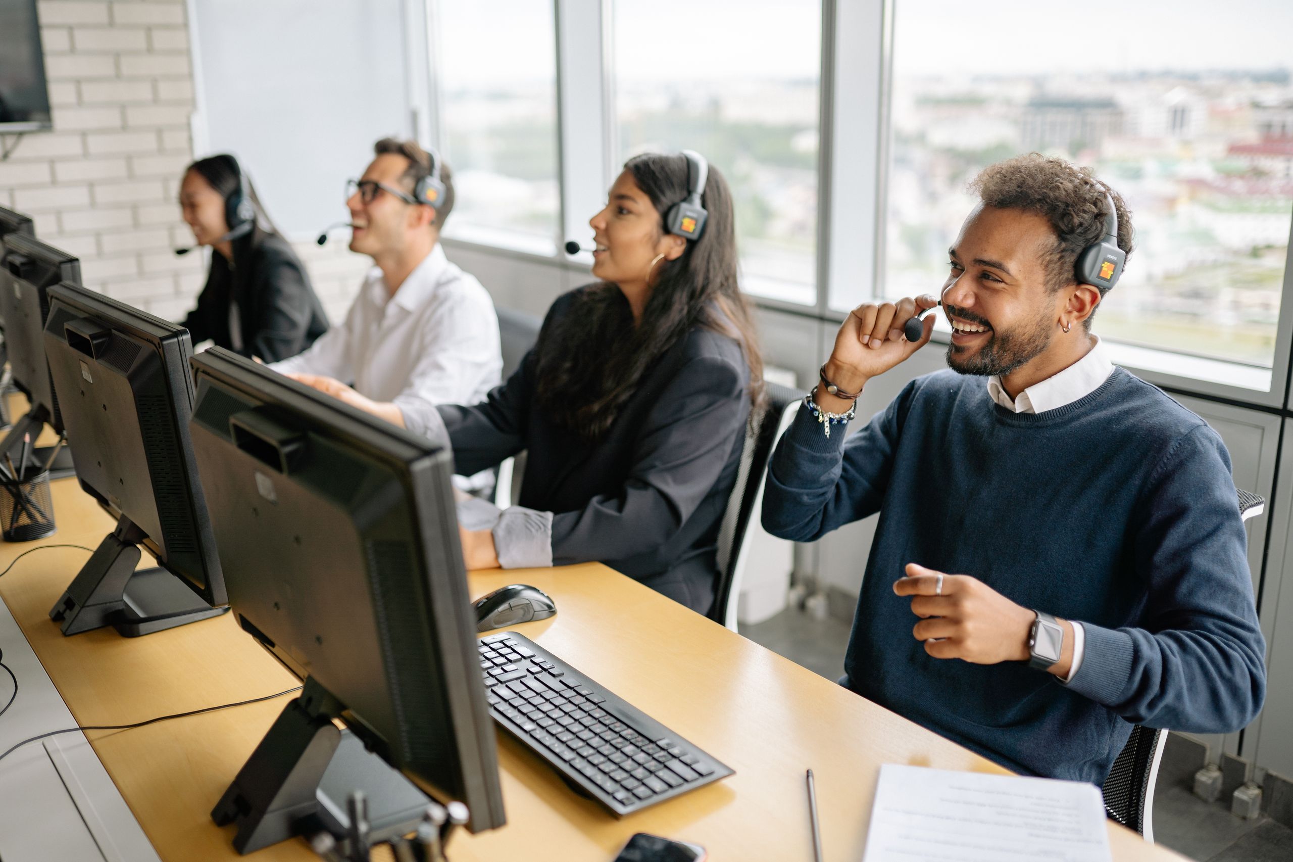 Group of professionals working in a modern call center, growing their careers by engaging with clients.